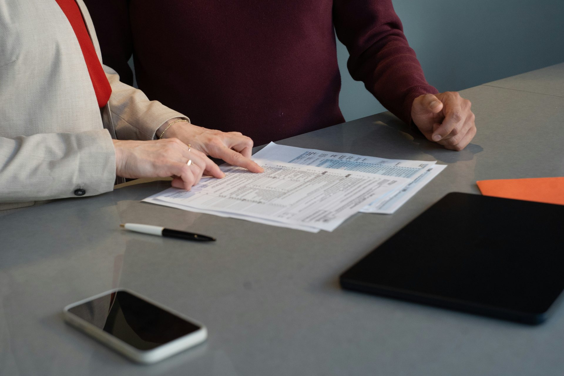 Deux personnes examinent des documents à une table.